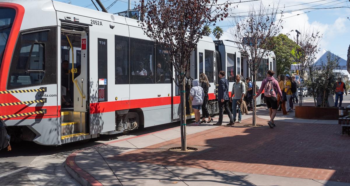 Photo of people boarding a Muni light rail vehicle using the new transit bulb on Irving Street.