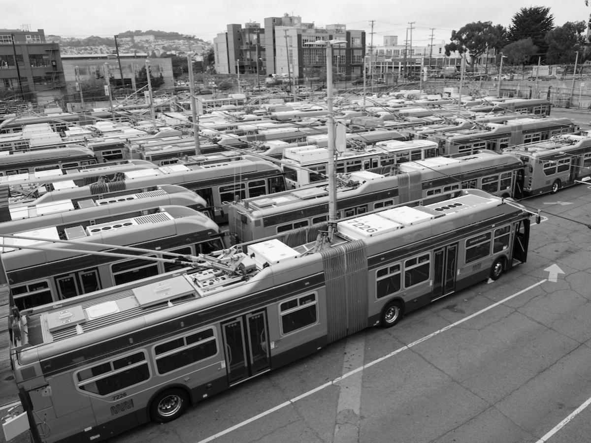 parked electric trolley buses packed tightly in a bus yard facility