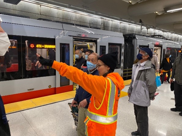 SFMTA Ambassador talking to customers on Metro station platform.