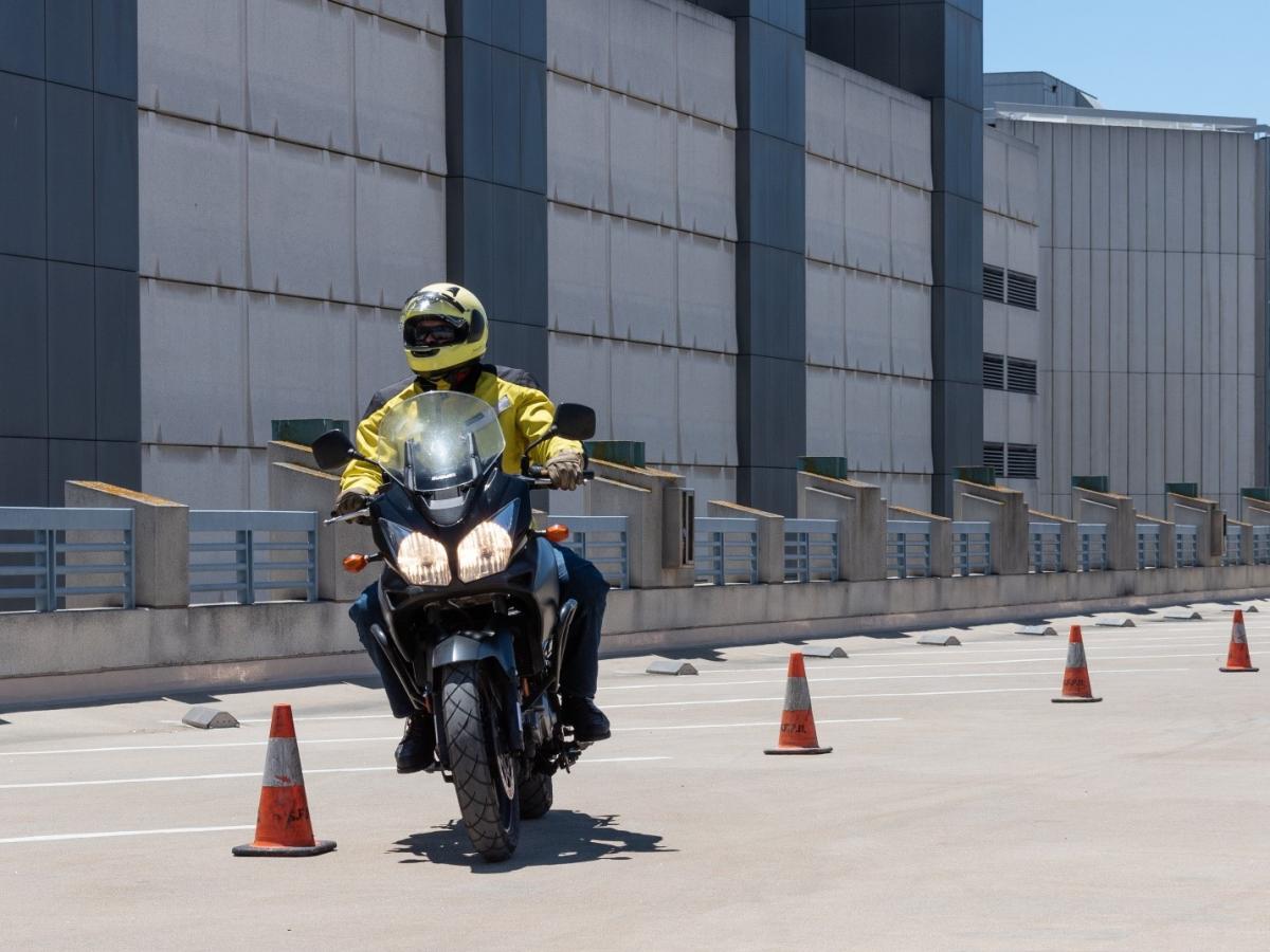 Image of motorcyclist weaving through cones during a motorcycle safety class.