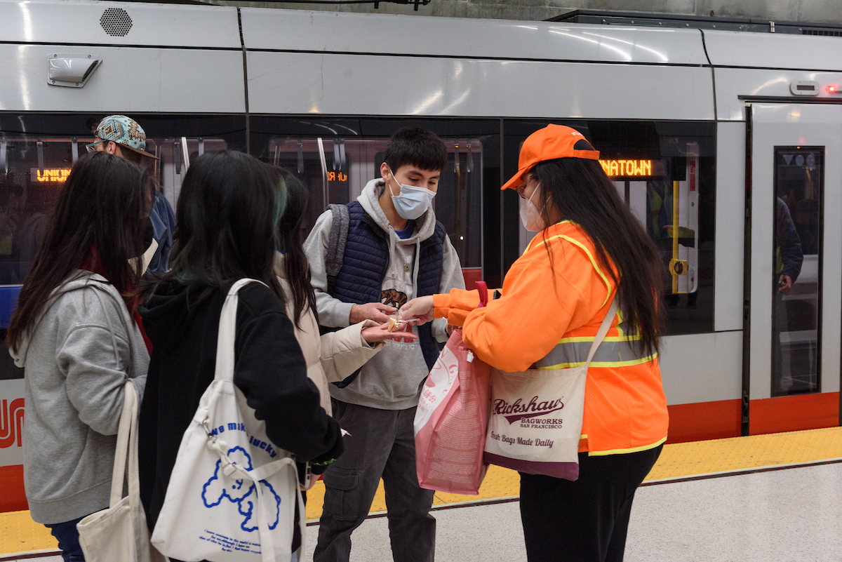 Ambassadors helping people at Union Square Station on opening day of free weekend shuttle service in Central Subway.