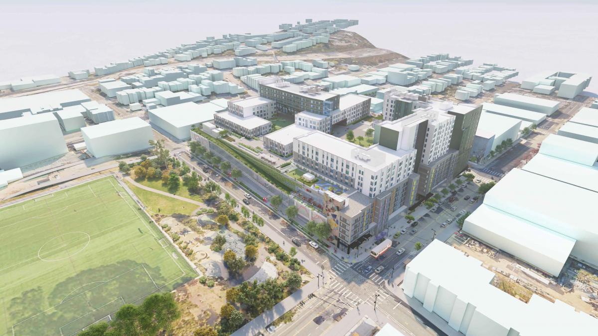 Rendering shows the Potrero Yard Modernization Project. Aerial view of a multi-unit building with green spaces. Across the street, we see a large green park and cars on a street. Buildings cover a hill in the background.