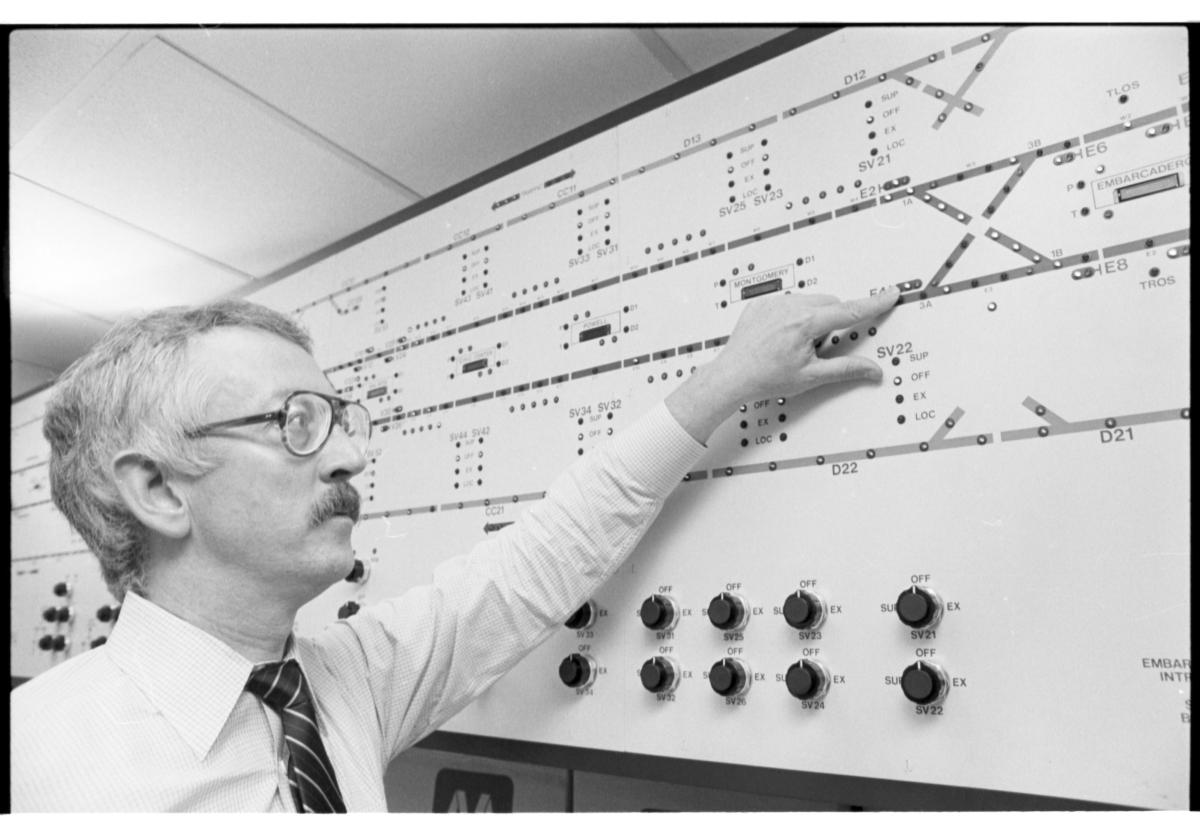 Vintage photo of man pointing at train control panel