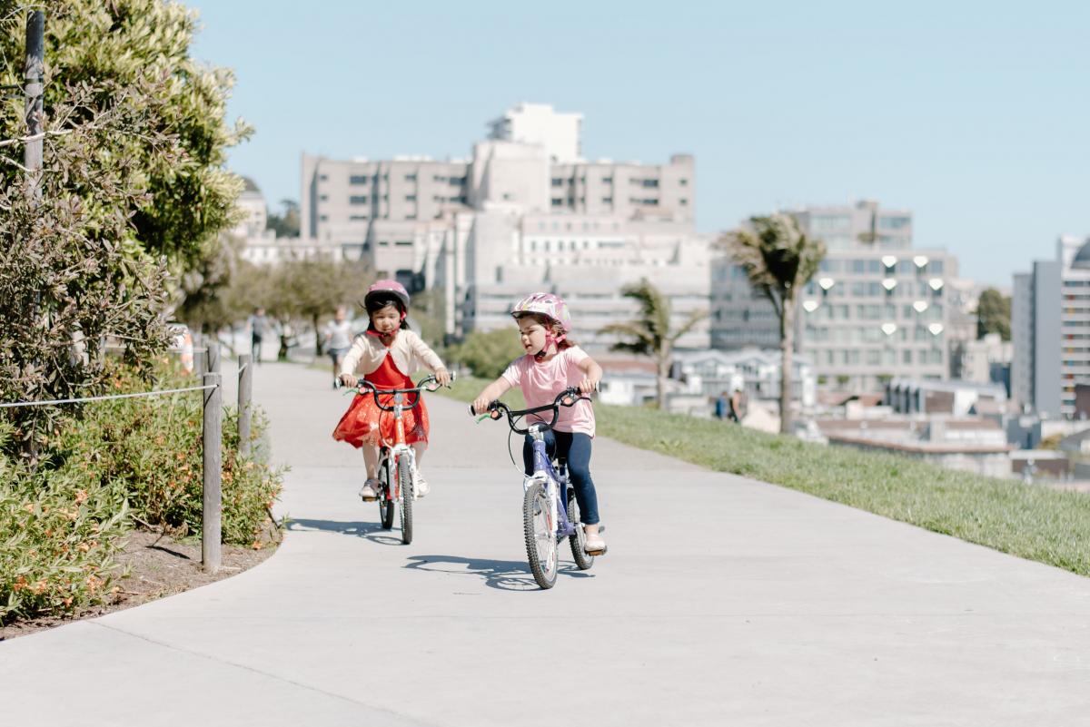 Young bicyclists on a road biking with helmets