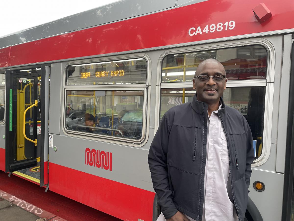 A man standing in front of a bus. 