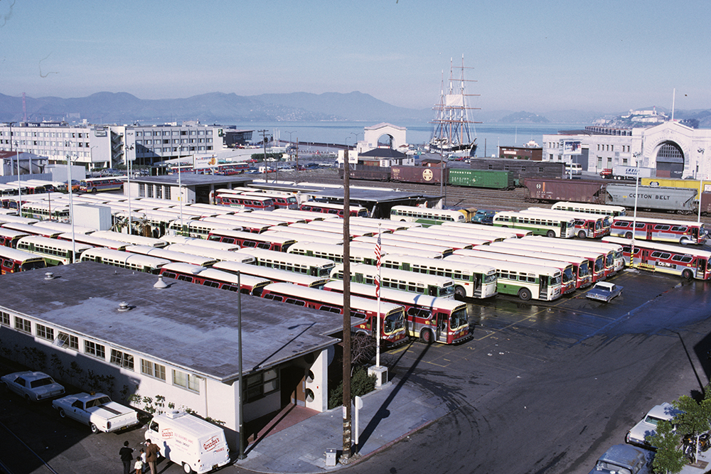 Aerial closeup of Kirkland Yard full of buses. Behind it are freight cars from a former freight yard.