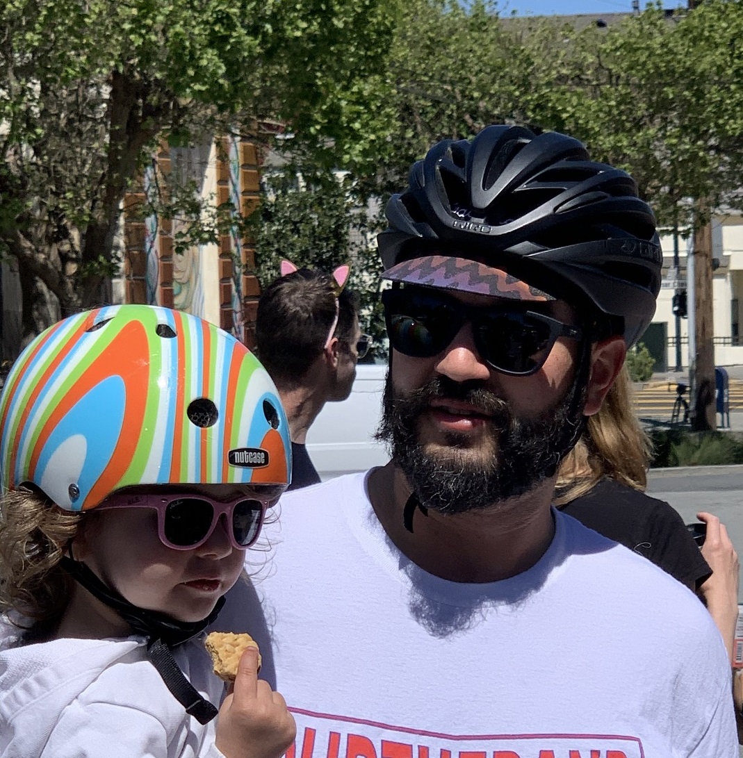 A father and daughter wearing bike helmets