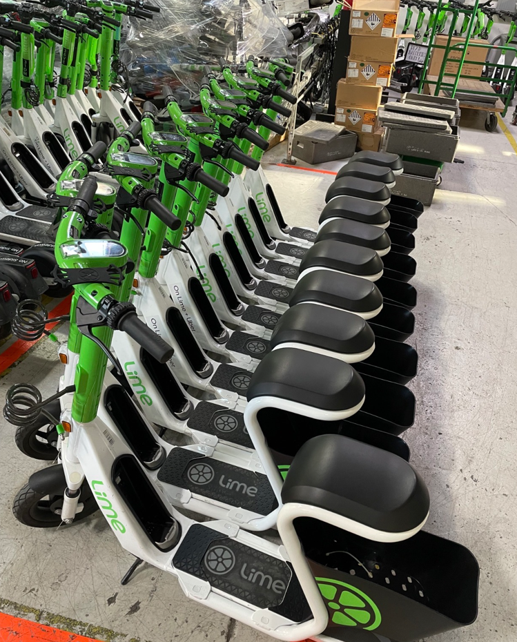 Lime green and white seated scooter with basket underneath the seat 