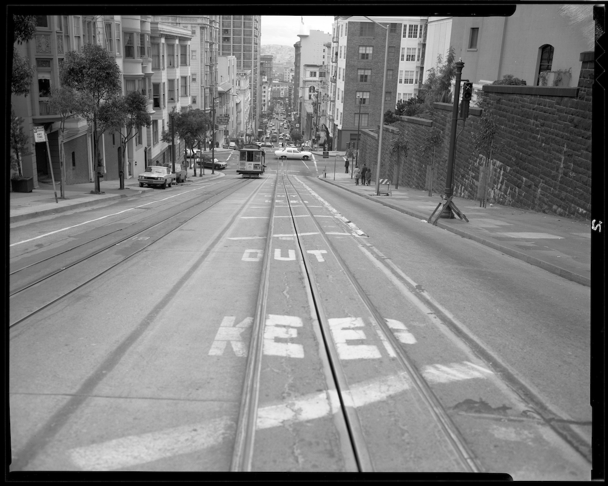 Cable car tracks with the words “keep out” painted over the street.