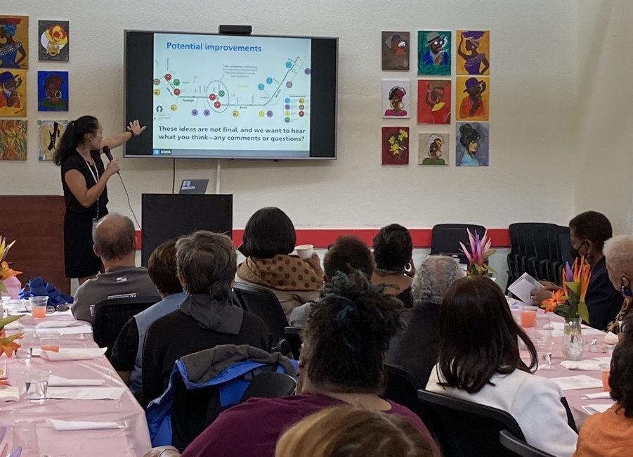 Participants at the OMI Senior Luncheon listen a presentation by SFMTA staff about the project.