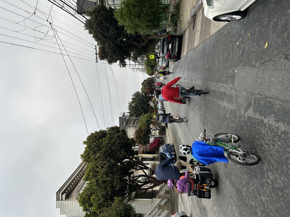 Kids, parents, and community members ride bikes down the Page Slow Street.