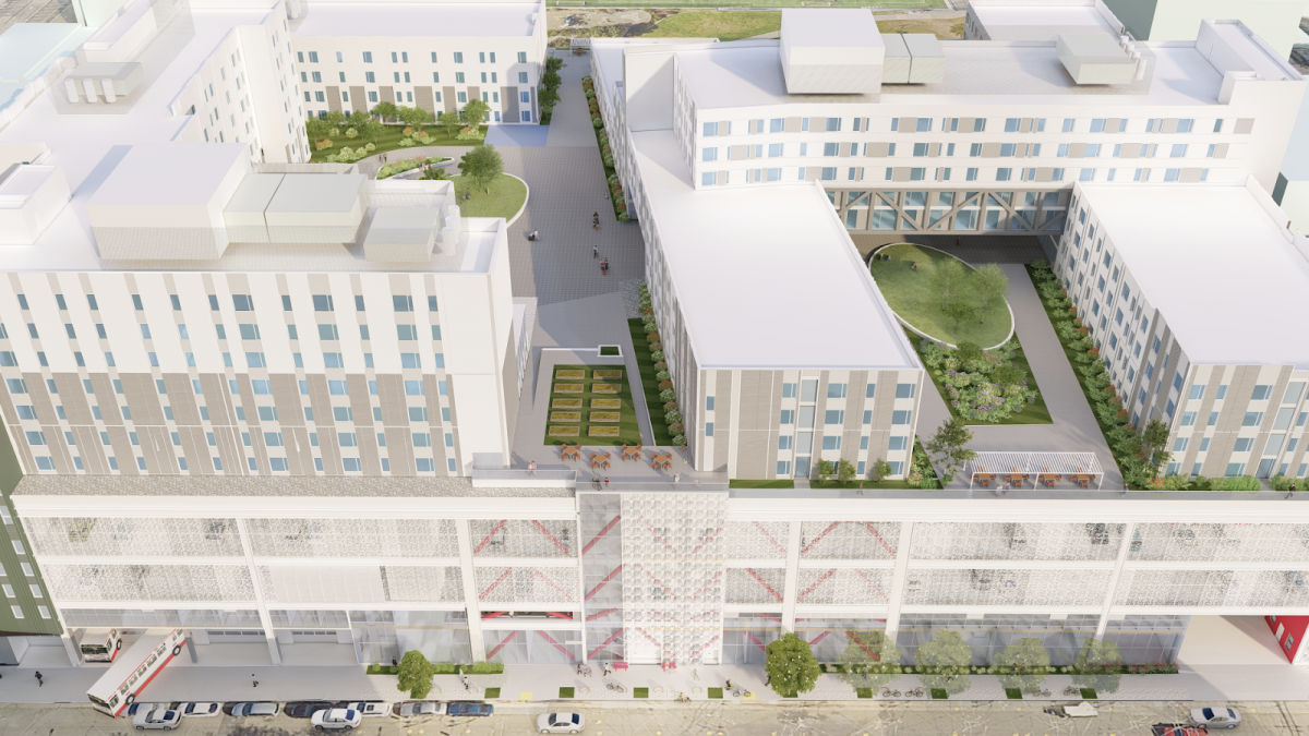 An aerial view of a large multi-use urban building, showing a podium, housing structures and with community garden and rooftop greenery spaces.