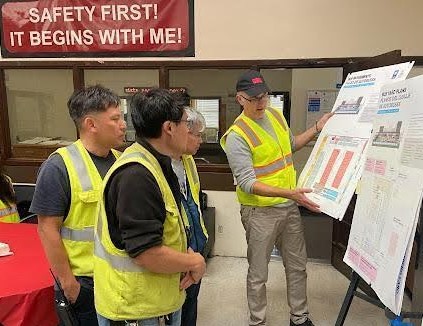 MUNI bus yard workers watching a presentation with SFMTA Staff discussing Project details