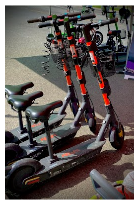 Orange and black seated scooter with basket attached to the front of the device