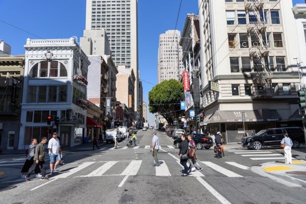 Pedestrians crossing Sutter Street at Grant Street in the crosswalk 