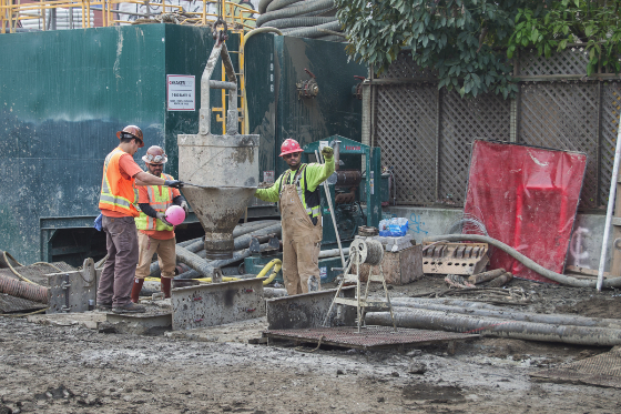 Workers calculate the amount of cement needed for a wall shaft by using a rubber ball as a bobble.