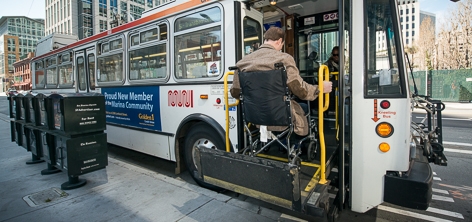 Passenger using a lift to enter a bus