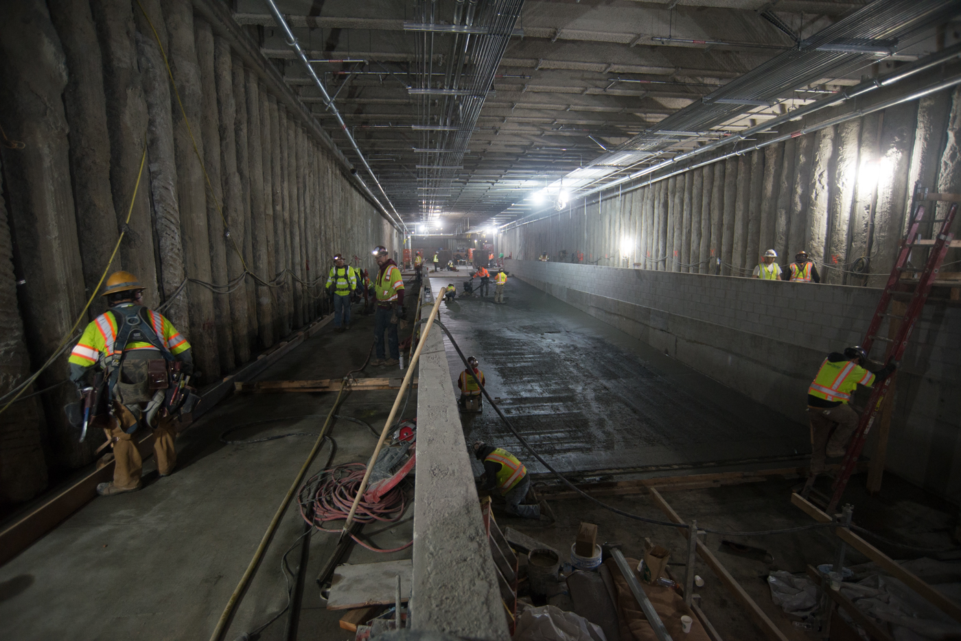 Workers have begun to pour concrete for an intermediate layer of the concourse floor slab, prior to installing<br />
    the finished terrazzo.