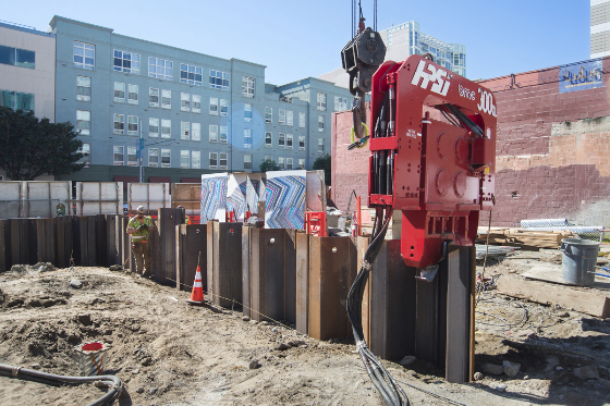 Steel sheet piles are<br />
        vibrated into the ground by a red machine called a vibro hammer at the future Yerba Buena/Moscone<br />
        Station.