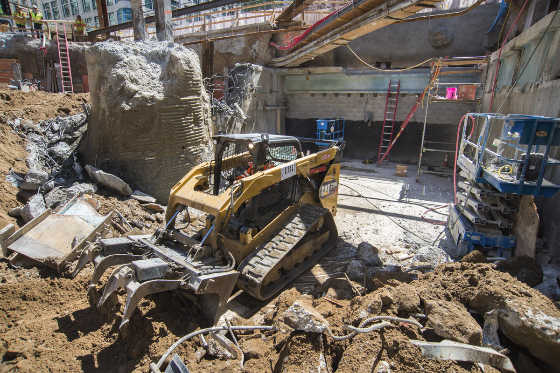 A worker uses a loader to move debris at Ellis and Stockton streets.