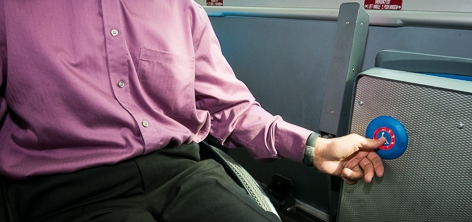 A passenger pushes the Accessible Stop Request button on a Hybrid Bus