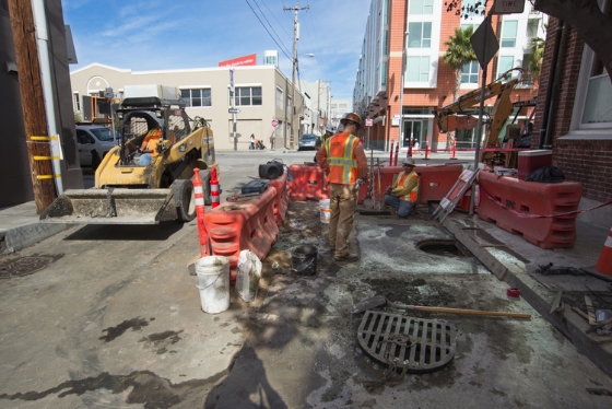 At the corner of 4th and Welsh streets, construction crews continue working on a manhole. Utilities along the<br />
    alignment are being relocated for the extension of the T Third Line.