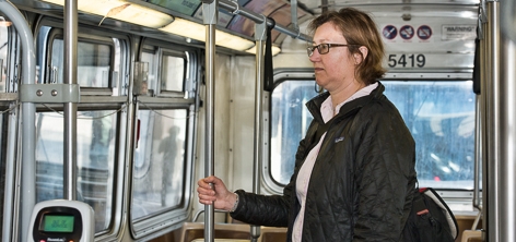 A passenger holds onto a stanchion for support during a bus ride