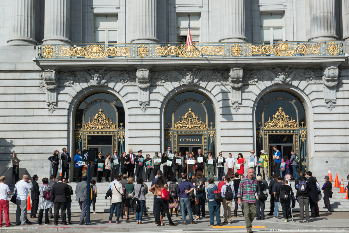 Polk Street steps of City Hall with crowd, dignitaries at podium on the top step.