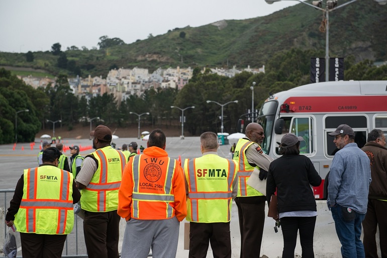 Spectators, SFMTA managers and other participants watch an operator take the course at the roadeo.