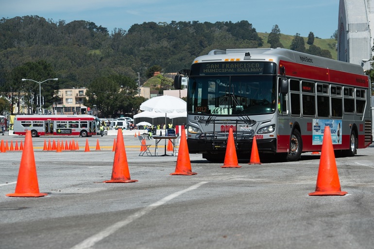 Muni bus navigating through orange safety cones for the bus safety roadeo.