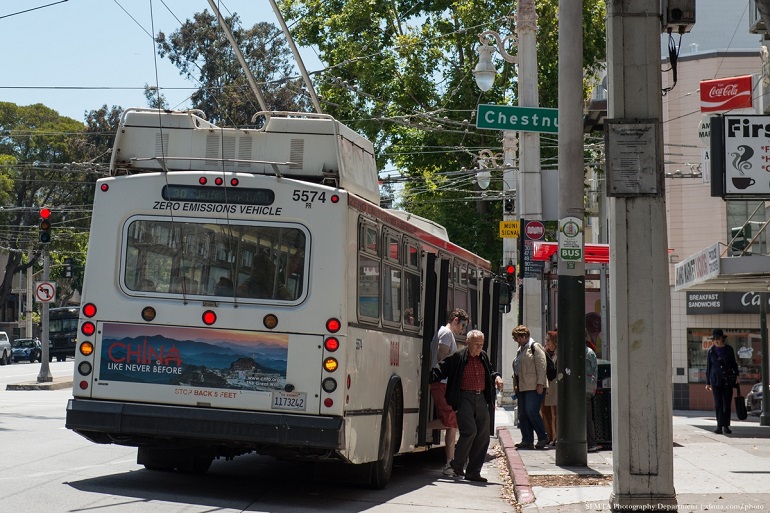 30 Stockton trolley bus pulls to the curb to pick up customers at a shelter stop.