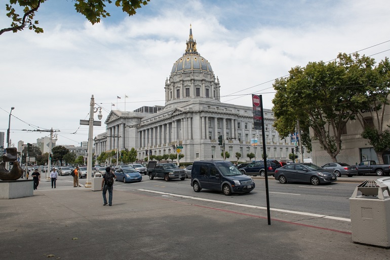Busy Van Ness Avenue with City Hall in the background.