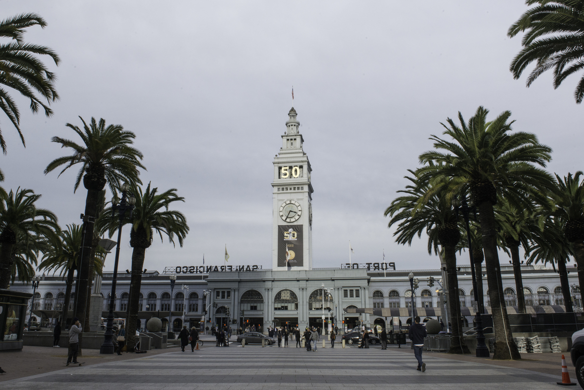 Wide shot of the Ferry Building with the gold Super Bowl "50" at the top and a black Super Bowl 50 on the front.