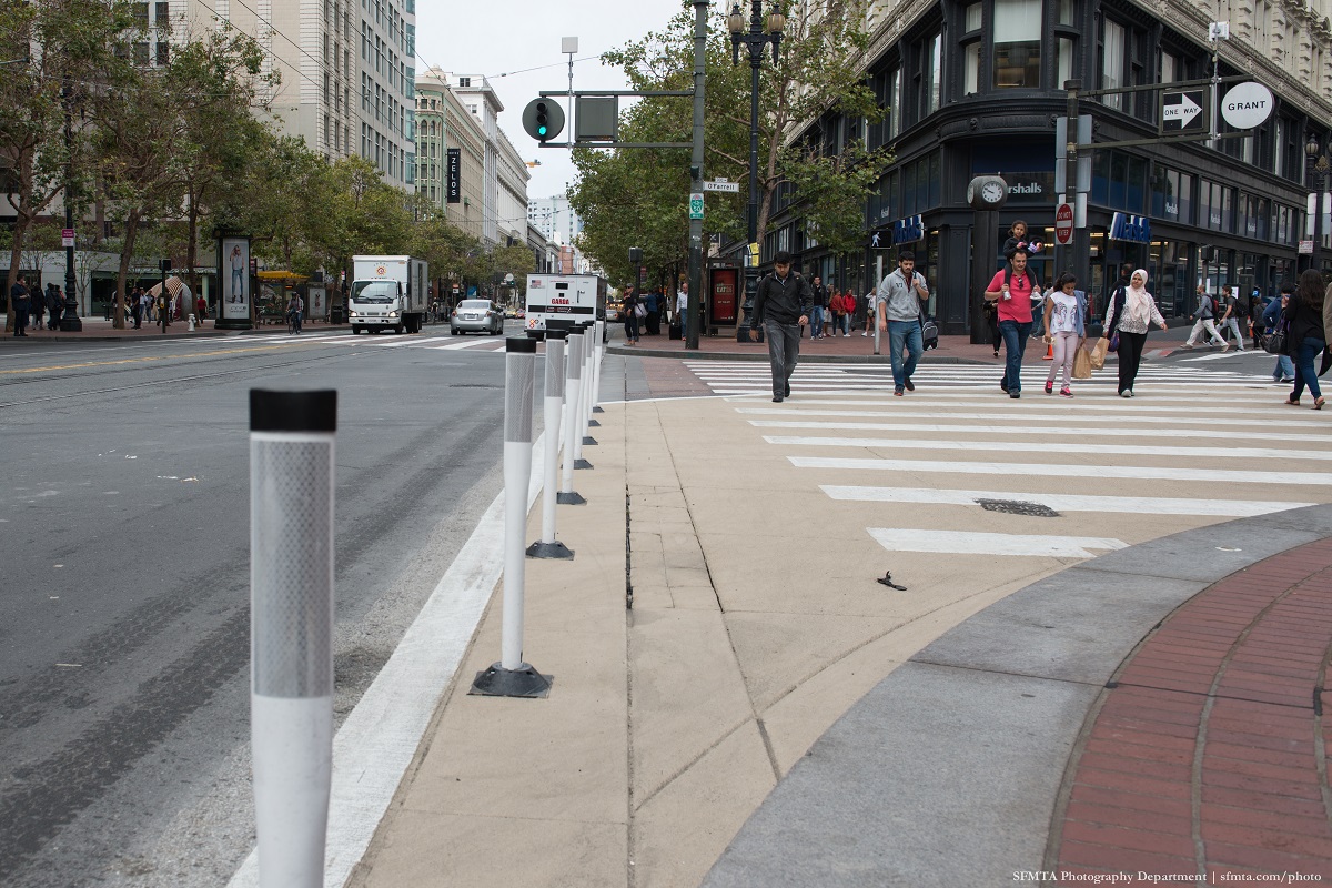 Safe-hit posts and zebra-striped continental crosswalks on Market Street.