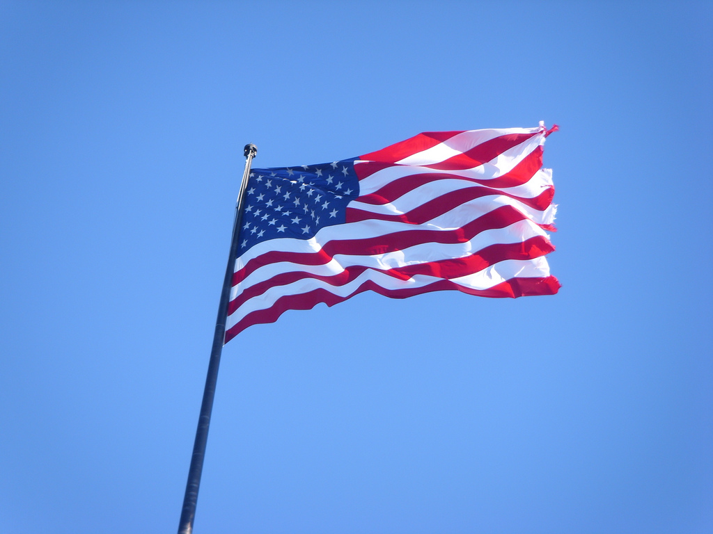Low-angle shot of the American flag against a blue sky