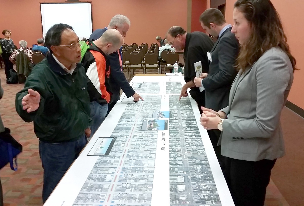 Members of the community meet with project staff while reviewing large diagrams of the proposed project.