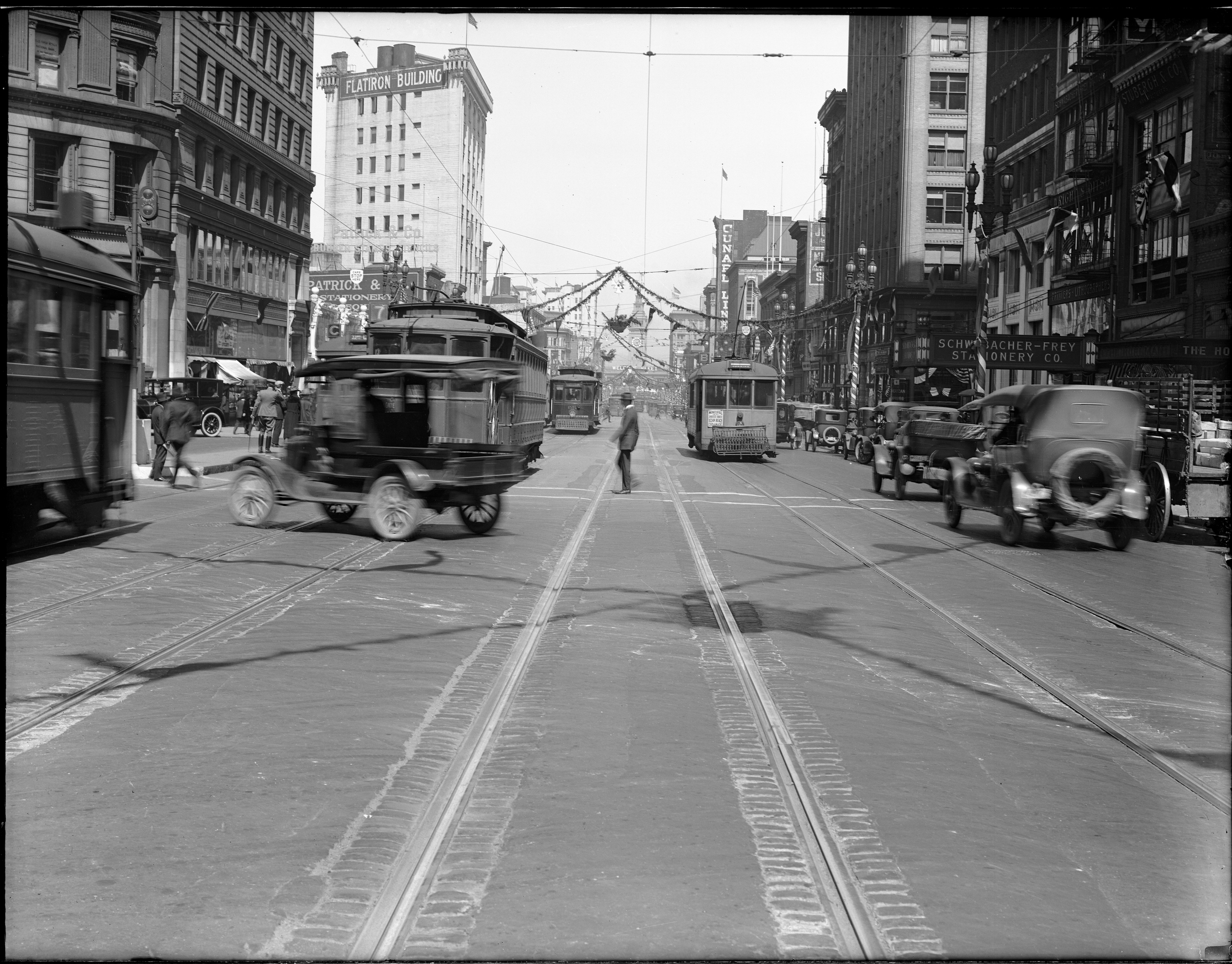 Early 20th century cars, streetcars and pedestrians on Market Street at New Montgomery looking east to Ferry Building.