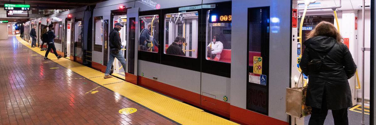 KT train at a station; people are boarding without social distancing; other people are already seated; all are wearing masks