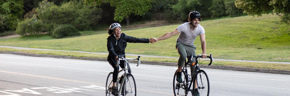 Two bikers holding hands on JFK Drive in GGP