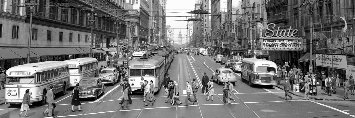 Historic photo of Market street with streetcars, busses and pedestrians.