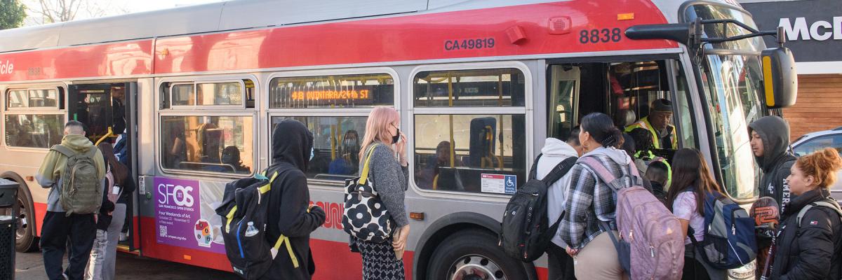 Muni bus with a many passengers boarding