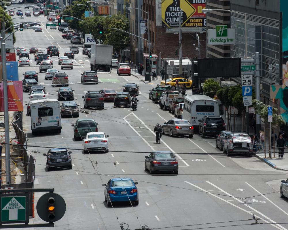 8th Street before: three travel lanes, cyclist riding in a bike lane, a car is traveling across the bike lane.