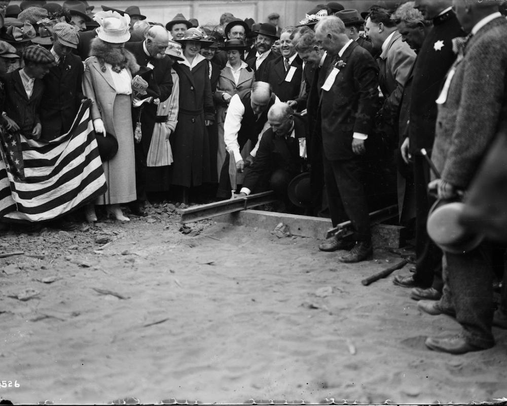 Mayor James Rolph Driving Ceremonial Spike for First Track Laid at the West Portal of the Twin Peaks Tunnel with Large Crowd | F