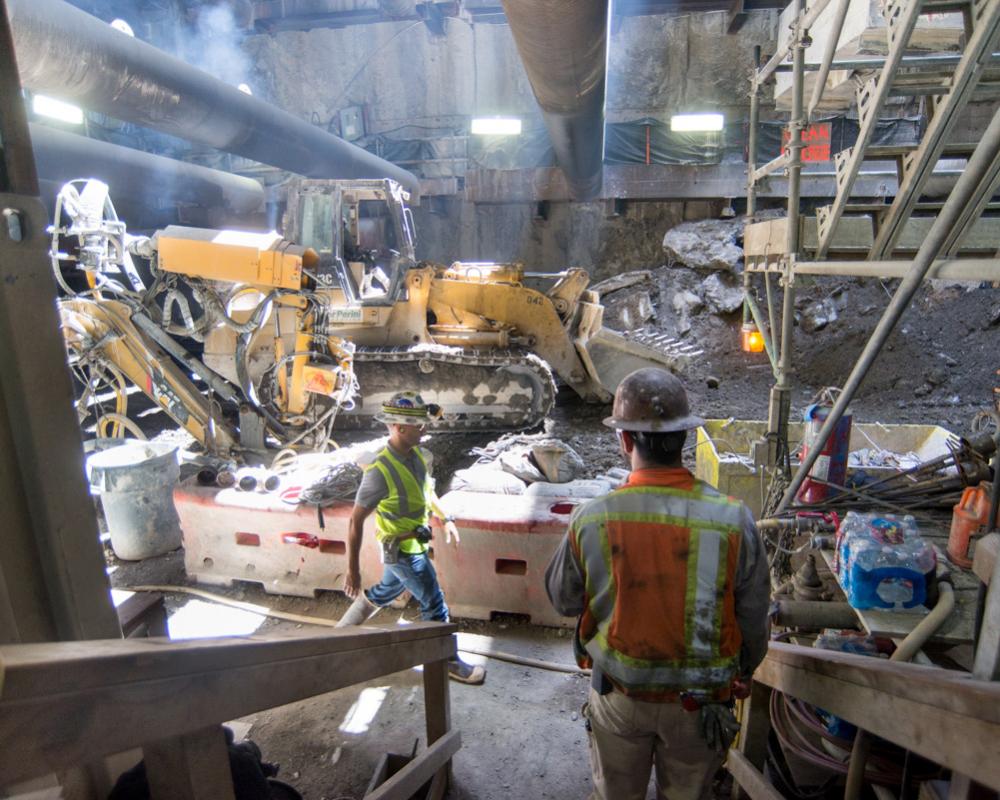 A large bulldozer approaches the excavation spoils collection and sorting area under the main access shaft inside the Chinatown 