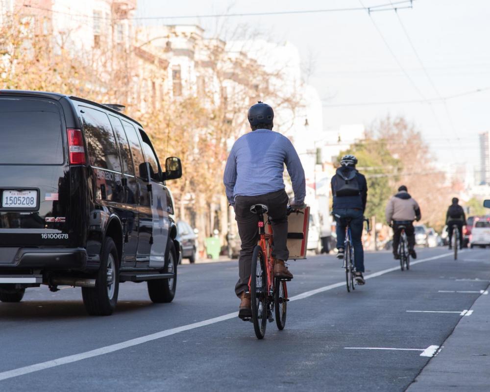 People biking and driving on Valencia Street