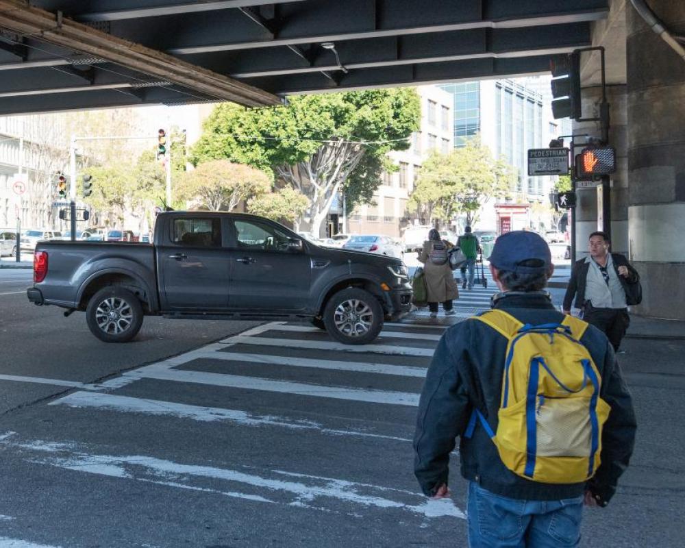 pedestrians walking in the crosswalk at 13th Street and Mission Street and a turning pick-up truck