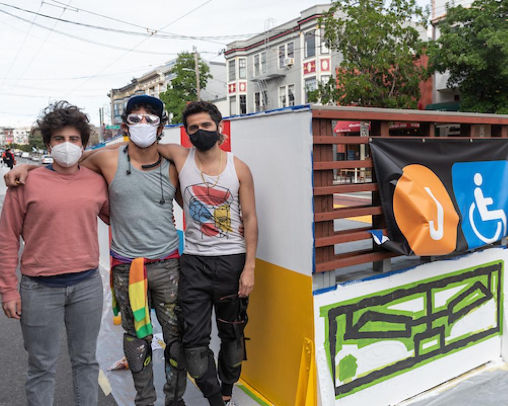 Simón Malvaez with friends in front of his mural "Them (Ramp)"