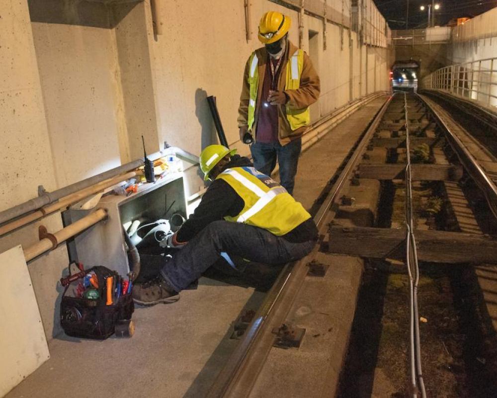 SFMTA Overhead Lines and Underground department perform preventative maintenance on a utility cable box at the Duboce Portal