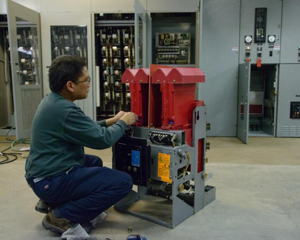 A man is kneeling in front a deck system piece inside a shops location.