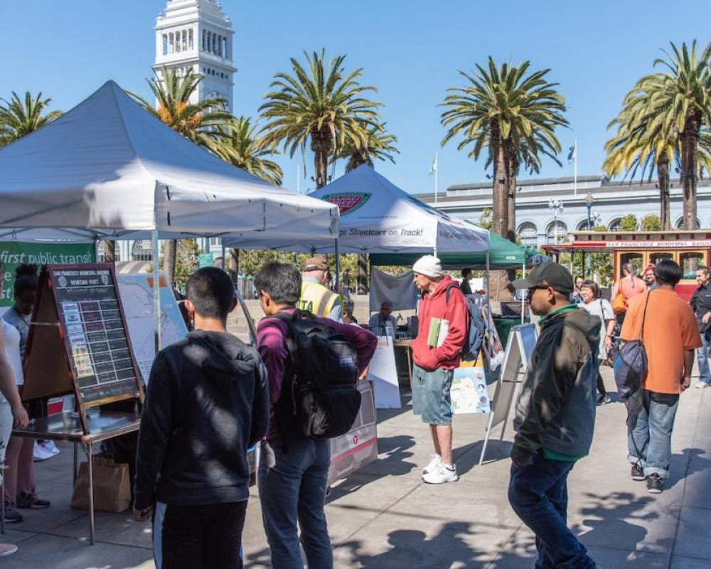 Muni Heritage attendees looking at information board at an event booth